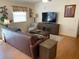 Comfortable living room with hardwood floors, a large window, and a modern entertainment center at 992 Davit Pl, The Villages, FL 32162