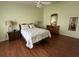 Comfortable main bedroom featuring neutral tones, hardwood floors, and side tables with lamps at 992 Davit Pl, The Villages, FL 32162