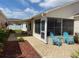 Inviting outdoor patio featuring screened enclosure, with comfortable seating and lush landscaping at 992 Davit Pl, The Villages, FL 32162