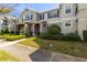 Attractive gray townhome featuring a well-manicured front yard with a covered entrance and blue shutters at 12313 Citruswood Dr, Orlando, FL 32832