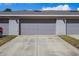 Modern two-car garage with gray doors and exterior lighting provides ample parking for residents at 12313 Citruswood Dr, Orlando, FL 32832