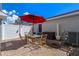 Cozy brick patio with table, chairs, a red umbrella, and white privacy fence is the perfect outdoor retreat at 12313 Citruswood Dr, Orlando, FL 32832