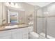 Bathroom featuring a modern vanity, toilet, and glass-enclosed shower with sleek gray tile and decorative accents at 1426 Powhatan Ct, Lakeland, FL 33805