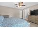 Primary bedroom boasts a ceiling fan, tv, and is connected to a walk-in closet and ensuite bathroom at 1426 Powhatan Ct, Lakeland, FL 33805