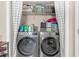 Stacked front load washer and dryer appliances within the laundry area with white shelving at 1426 Powhatan Ct, Lakeland, FL 33805