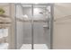 A modern shower with glass doors, gray tile, a decorative tile accent stripe, and dual shower heads at 1426 Powhatan Ct, Lakeland, FL 33805