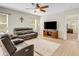 Cozy living room featuring wood-look flooring, neutral walls, a comfortable leather sofa, and a ceiling fan at 3214 Bayou Bay Dr, Lakeland, FL 33811