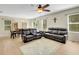 Spacious living room with wood-look flooring, featuring comfortable leather seating and a view of the dining area at 3214 Bayou Bay Dr, Lakeland, FL 33811