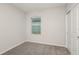 A bright bedroom with gray carpet, a window with blinds, and a closet with white sliding doors at 5421 Sw 82Nd Ter, Ocala, FL 34481
