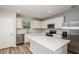 Modern kitchen features white cabinets, stainless steel appliances, and a center island with white countertop at 5421 Sw 82Nd Ter, Ocala, FL 34481