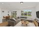 Bright living room featuring neutral decor, a sectional sofa, and large windows offering backyard views at 9009 Sw 52Nd Place Rd, Ocala, FL 34481