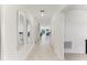 Long hallway with tile flooring, white walls, and mirrors leading to other rooms at 4323 Trotters Way, Lakeland, FL 33801