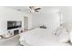 Bright main bedroom has large bed, entertainment center with tv, and white walls at 4323 Trotters Way, Lakeland, FL 33801