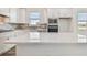 Bright, modern kitchen with stainless steel appliances, quartz countertops, and tile backsplash at 8731 Sw 57Th Ln, Ocala, FL 34481