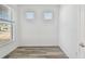 Bright room features wood-look floors, white walls, and a large window overlooking the neighborhood at 8731 Sw 57Th Ln, Ocala, FL 34481