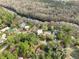 Aerial view showcasing the community, homes with pools, and the Santa Fe River winding along a wooded area at 10774 Sw 185Th Ter, Dunnellon, FL 34432