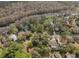 Aerial view showcasing the community, homes, and a large pond winding along a wooded area at 10774 Sw 185Th Ter, Dunnellon, FL 34432