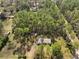 Aerial view showcasing the home with a backyard shed surrounded by tall, mature trees at 10774 Sw 185Th Ter, Dunnellon, FL 34432