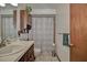 Cozy bathroom features a sink with wood cabinets, a toilet, and a shower with patterned curtain at 10774 Sw 185Th Ter, Dunnellon, FL 34432