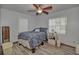 A bedroom features a ceiling fan, light walls, wood floors, and a blue paisley comforter at 10774 Sw 185Th Ter, Dunnellon, FL 34432