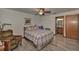 Cozy bedroom with a ceiling fan, wood-look flooring, and an ensuite bathroom at 10774 Sw 185Th Ter, Dunnellon, FL 34432