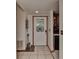 Entryway with tile flooring and a diamond pattern glass window in the white front door at 10774 Sw 185Th Ter, Dunnellon, FL 34432