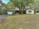 Charming single-story home featuring a stone accent wall, two-car garage, and large shade tree at 10774 Sw 185Th Ter, Dunnellon, FL 34432