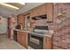 Kitchen with brick accent wall, laminate cabinets, and black appliances at 10774 Sw 185Th Ter, Dunnellon, FL 34432