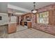 Bright kitchen featuring tile flooring, brick walls, wooden cabinets, and stainless steel appliances at 10774 Sw 185Th Ter, Dunnellon, FL 34432