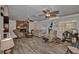 Living room with hardwood floors, stone fireplace, ceiling fans, and natural light at 10774 Sw 185Th Ter, Dunnellon, FL 34432