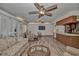 Spacious living room with wood-look floors, multiple ceiling fans, and a large window for natural light at 10774 Sw 185Th Ter, Dunnellon, FL 34432