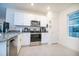 Well-lit kitchen featuring stainless steel appliances, granite countertops, white cabinets, and tiled flooring at 469 Liu Ln, Deland, FL 32724