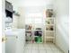 Bright laundry room featuring a washing machine and storage shelves at 2001 Cricket Dr, Orlando, FL 32808