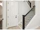 Hallway with staircase, showcasing black railings and light wood steps, plus entry door at 2308 Depauw Ave, Orlando, FL 32804