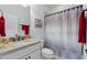 Cozy bathroom featuring a shower curtain, patterned walls, and a stylish mirror above the sink at 439 Toldedo Rd, Davenport, FL 33837