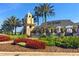 The Del Webb community entrance with lush landscaping, fountain and beautiful red flowers at 439 Toldedo Rd, Davenport, FL 33837