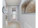 Inviting foyer featuring neutral tile flooring, decorative door and an elegant painting of a tree on the wall at 439 Toldedo Rd, Davenport, FL 33837