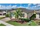Well-kept home featuring stone accents, verdant landscaping, and a paver driveway leading to a two-car garage at 439 Toldedo Rd, Davenport, FL 33837