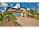 Well-kept home featuring stone accents, verdant landscaping, and a paver driveway leading to a two-car garage at 439 Toldedo Rd, Davenport, FL 33837