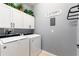 Well-organized laundry room with white cabinetry, modern appliances, and decorative accents at 439 Toldedo Rd, Davenport, FL 33837