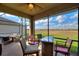 Inviting screened patio featuring a table, chairs, and picturesque views of the surrounding landscape at 439 Toldedo Rd, Davenport, FL 33837