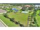 Vibrant green lawn with fenced in area for pet recreation, lush trees, and common playground at 439 Toldedo Rd, Davenport, FL 33837