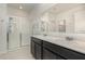 Bright bathroom featuring double vanity, granite countertop, and a glass-enclosed shower at 1006 Breggia Ct, Haines City, FL 33844