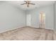 Light-filled bedroom with neutral carpet, ceiling fan, and a door to en suite bathroom at 1006 Breggia Ct, Haines City, FL 33844