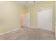 Bedroom with two doors, neutral carpet, and light yellow walls at 1006 Breggia Ct, Haines City, FL 33844