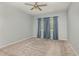 Spacious bedroom with neutral carpet, ceiling fan and three windows with curtains at 1006 Breggia Ct, Haines City, FL 33844