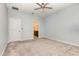 Large bedroom with a ceiling fan, neutral carpet, and view to the en suite bathroom at 1006 Breggia Ct, Haines City, FL 33844