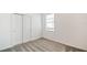 Well-lit bedroom with neutral carpet, double-door closet, and a window, creating a versatile and welcoming space at 1671 Ruby Ln, Lake Alfred, FL 33850