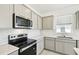 Contemporary kitchen with sleek stainless steel appliances, marble backsplash, and ample cabinet space at 1671 Ruby Ln, Lake Alfred, FL 33850