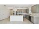 Modern kitchen featuring stainless steel appliances, a large island, and stylish gray cabinets with marble countertops at 1671 Ruby Ln, Lake Alfred, FL 33850